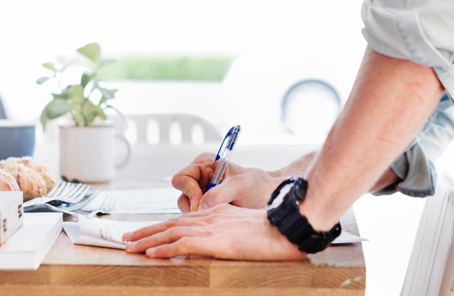 Man writing on notepad on a desk