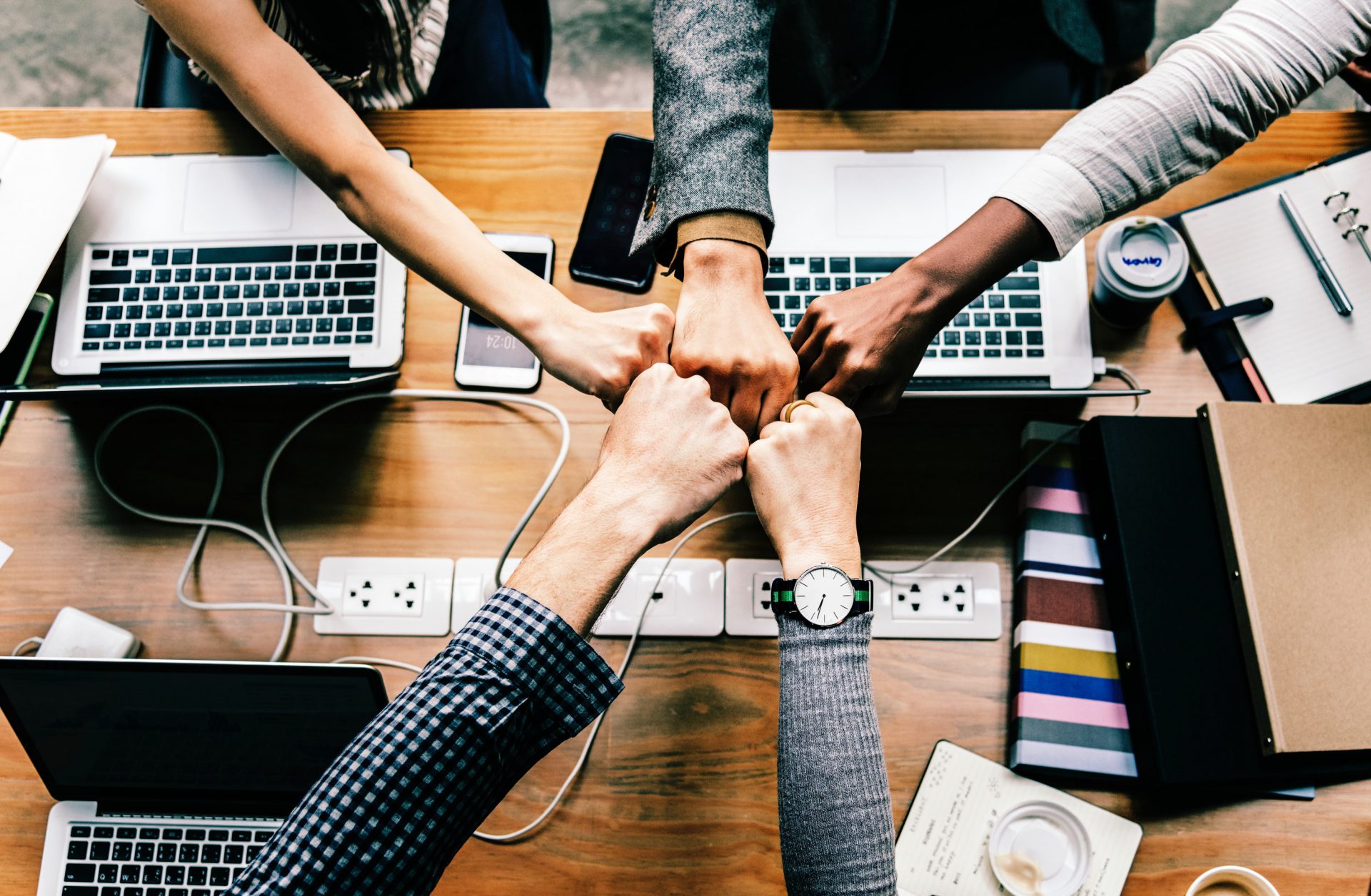 business team meeting handshake with laptops and mobile devices in a desk