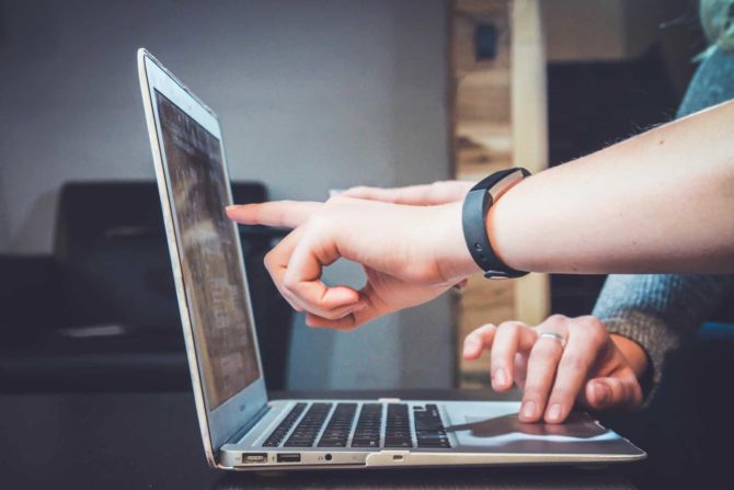 Researcher pointing out something on a laptop screen