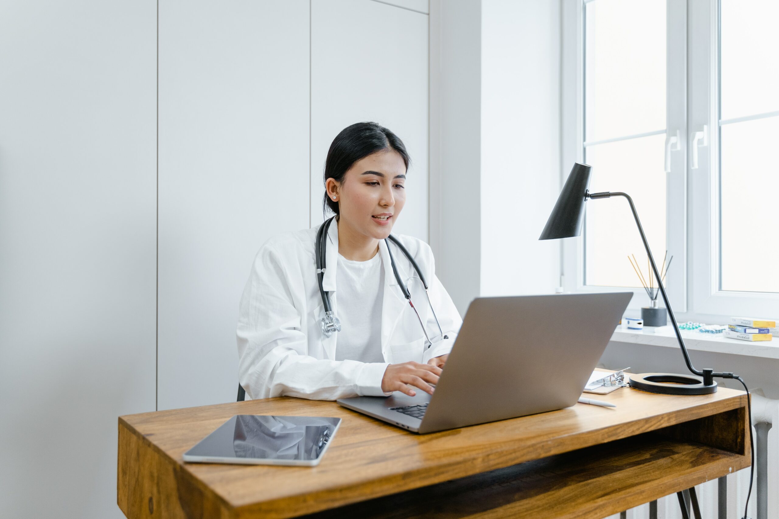 Doctor at their desk in their office working on a laptop